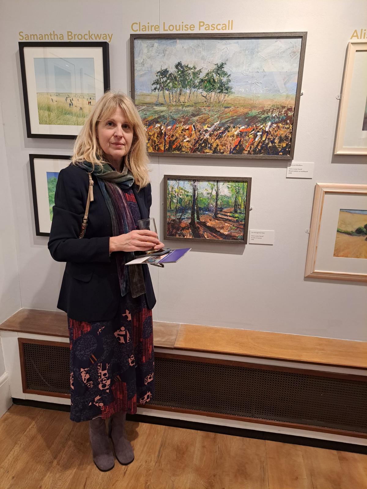 Claire at an exhibition with two of her paintings